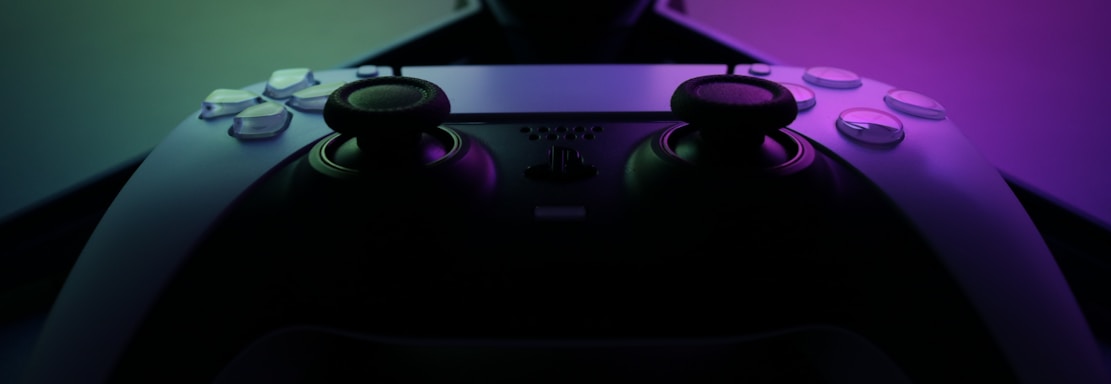 A sleek gaming controller resting on a vibrant gradient background with subtle glowing effects.